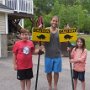 The Colotti famliy holding their "Critter Crossing" signs.