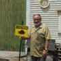 Carl Pearson holding his "Critter Crossing" sign.